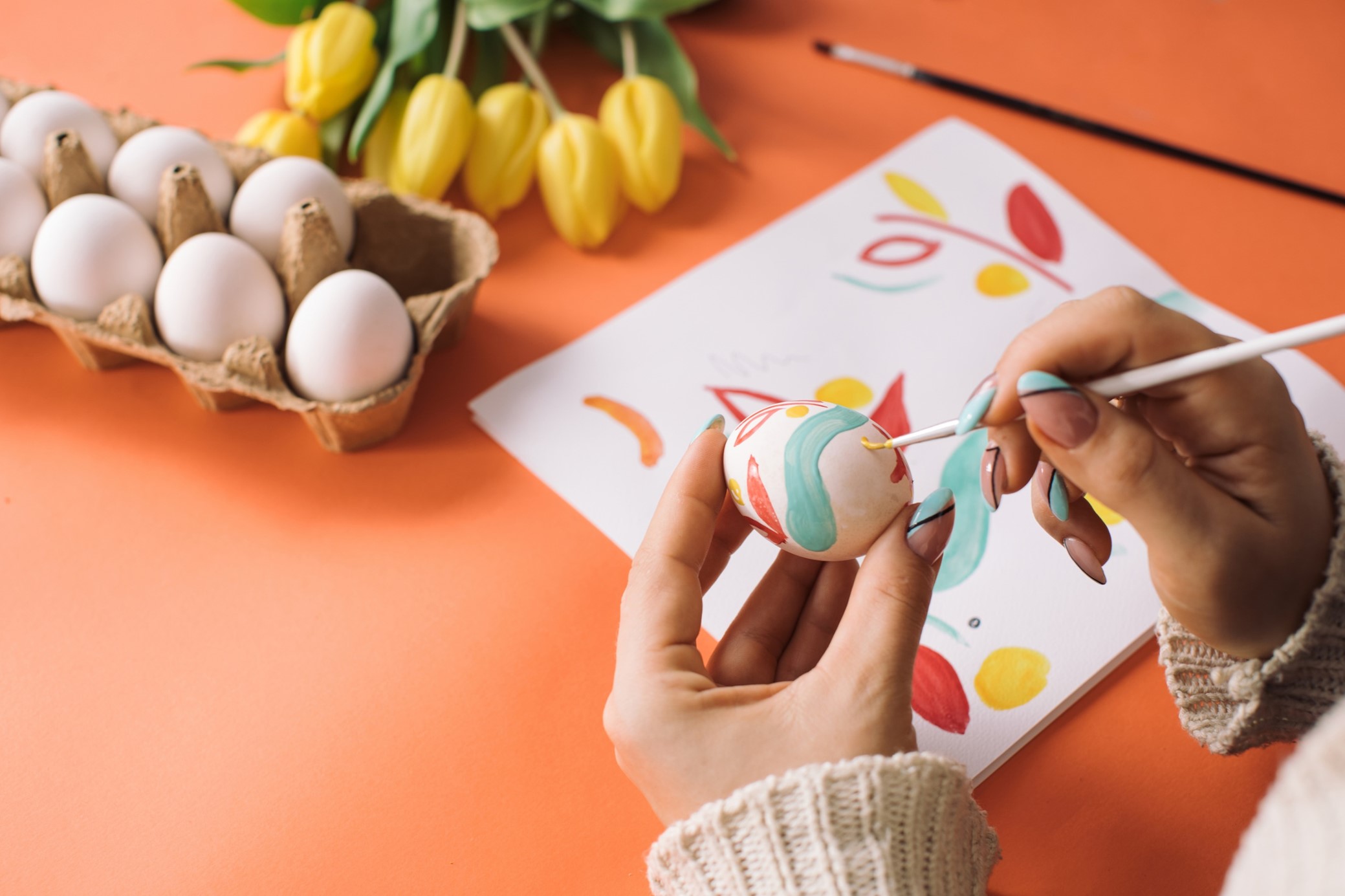 Person målar ägg i glada färger