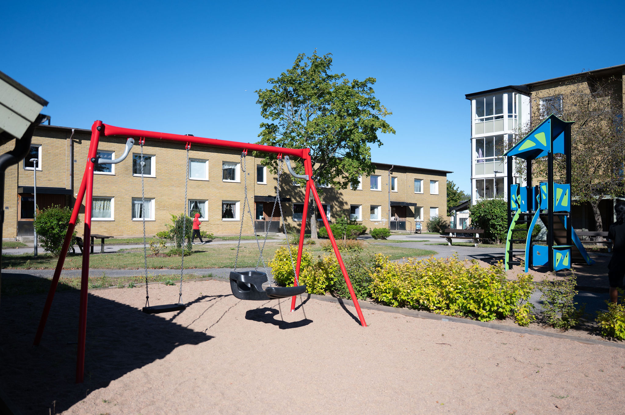 Gård med lekplats och röd gunga