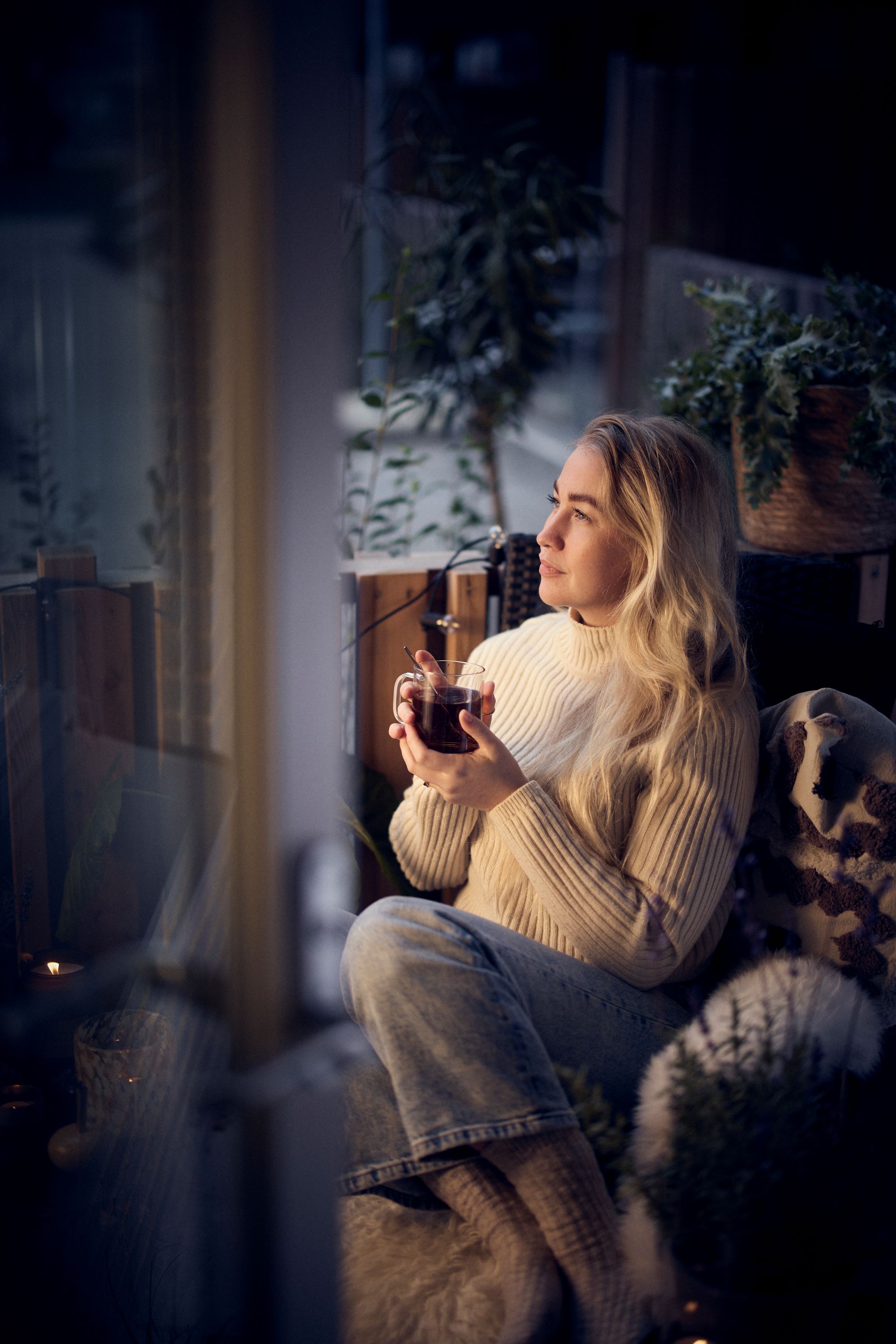 Ung kvinna sitter på sin uteplats 