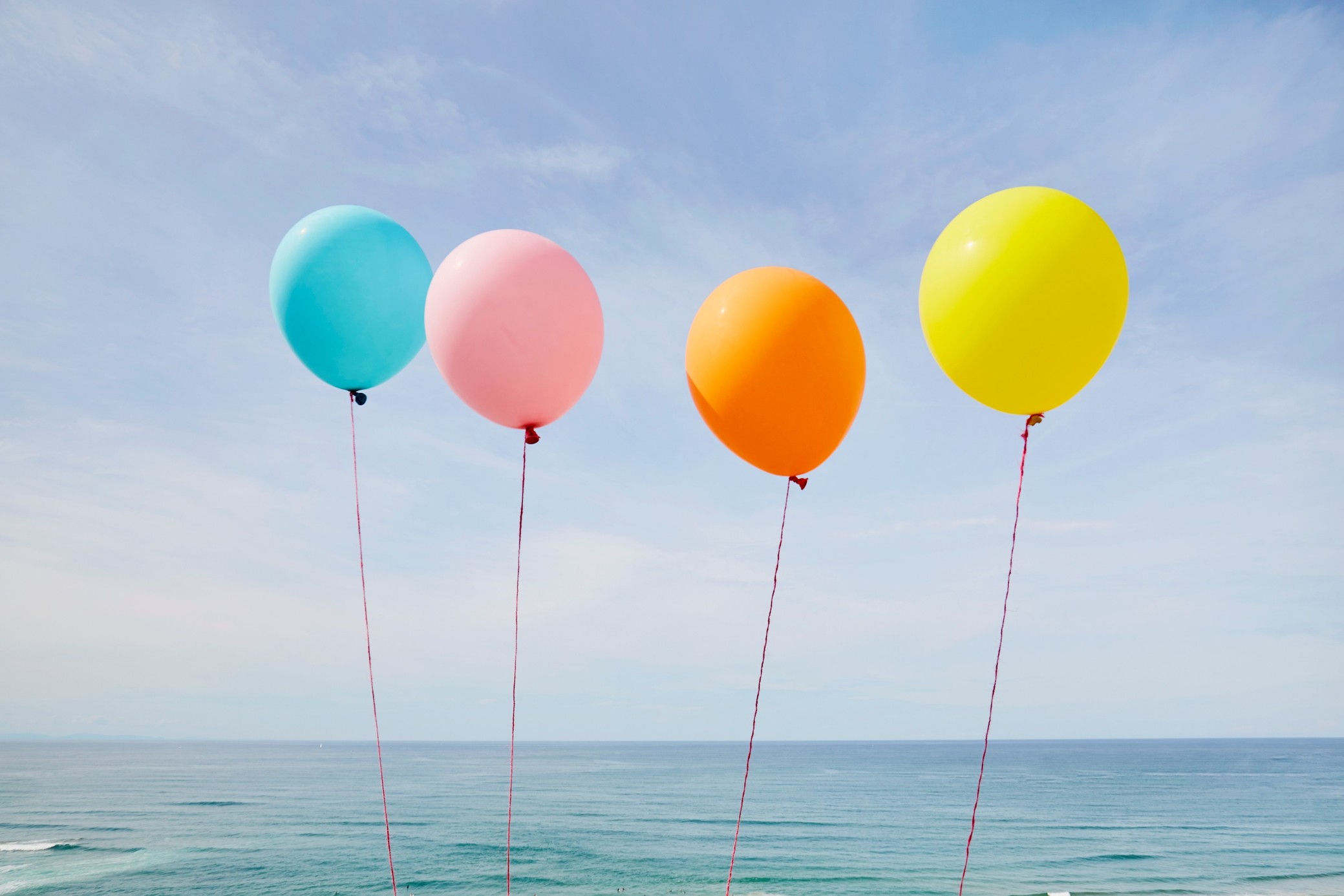 Färgglada ballonger flyger över havet